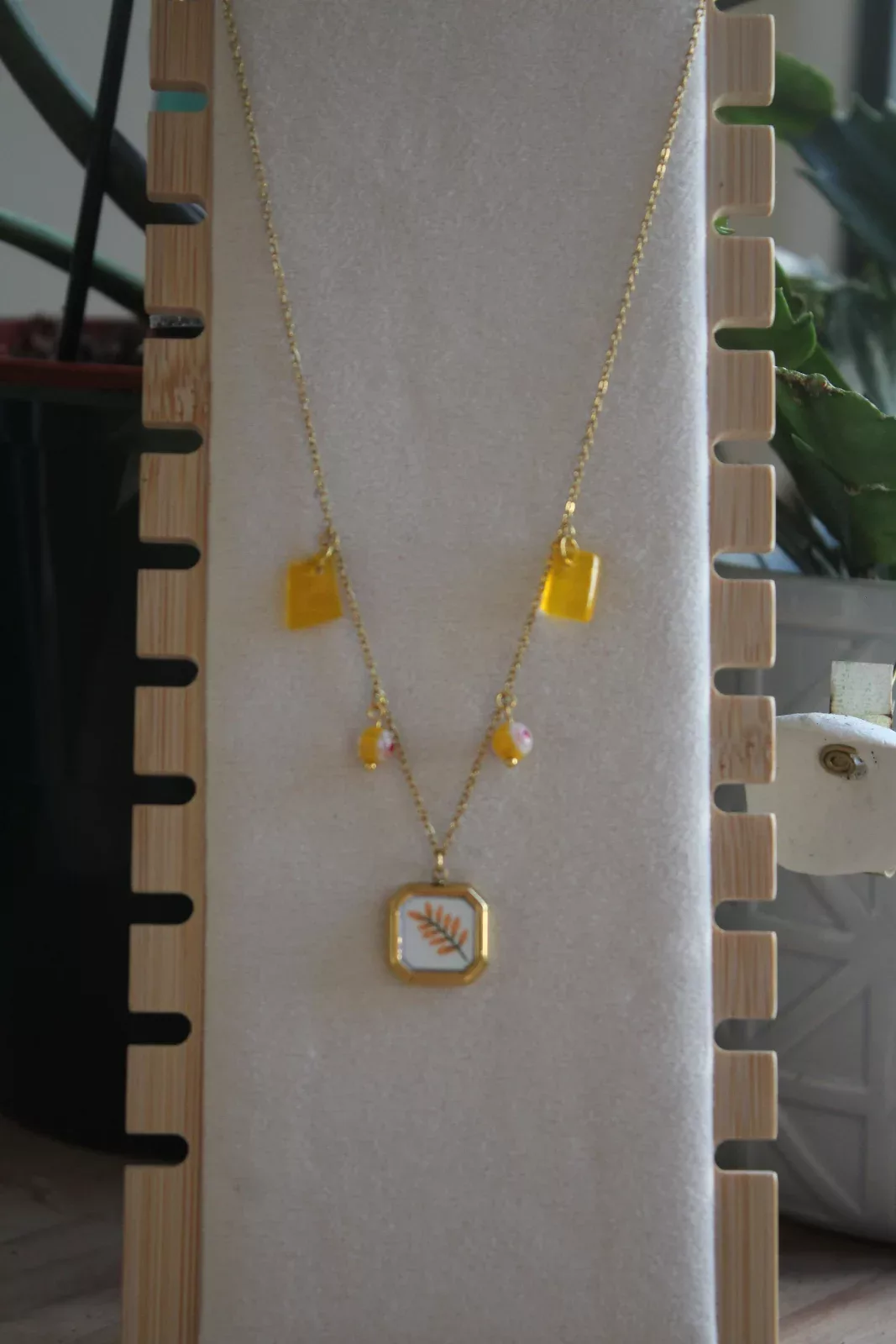 Collier à pampilles jaune et pendentif motif végétal