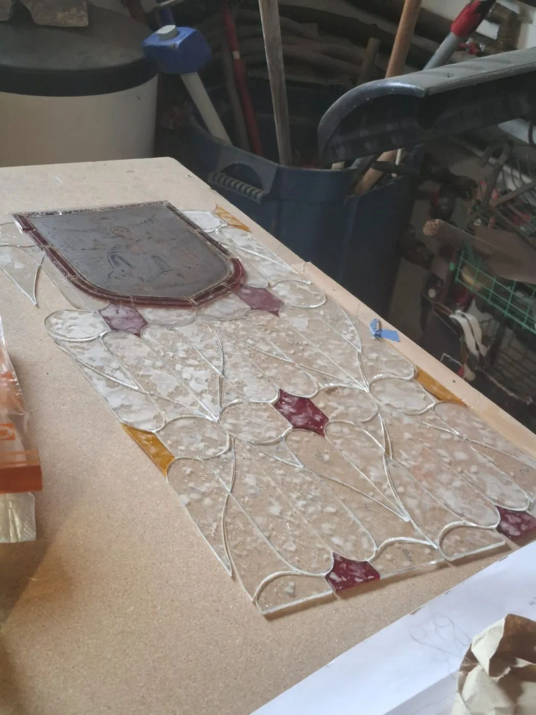 Verres coupés et blason ancien de la chapelle Sainte-Anne posés à plat à l'atelier